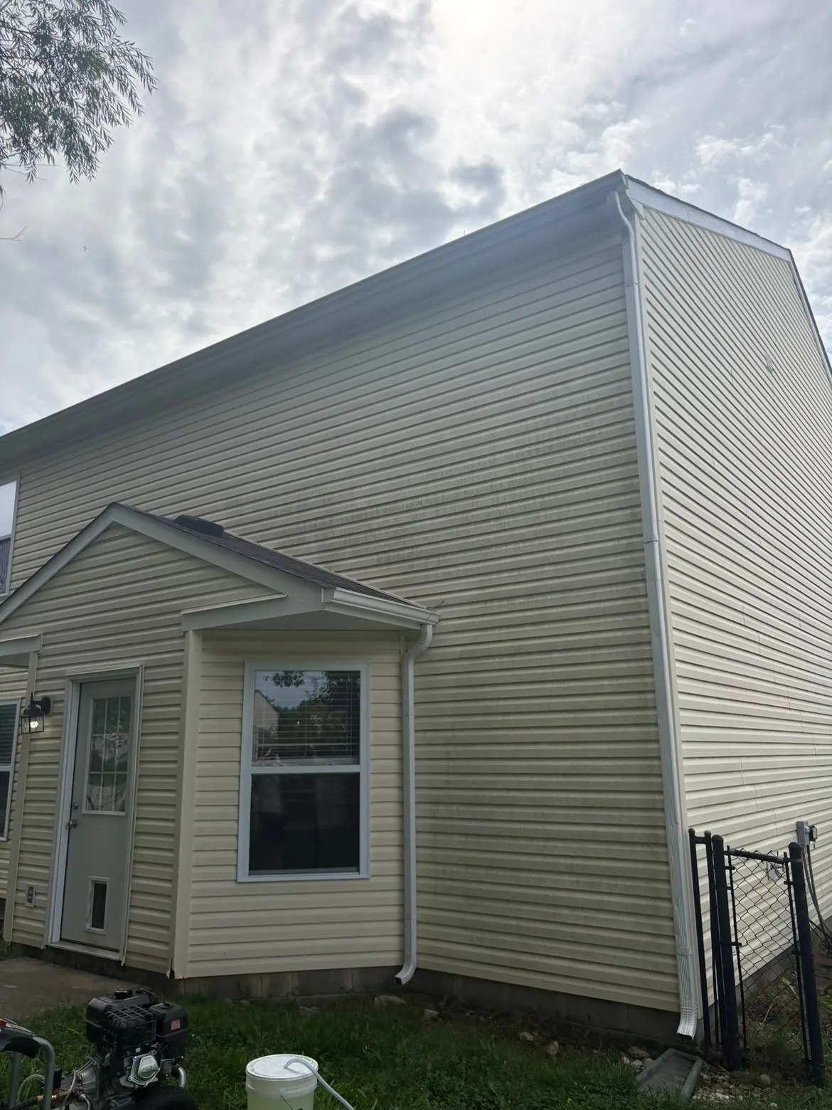 Before: the back of a house, its vinyl siding streaked green.