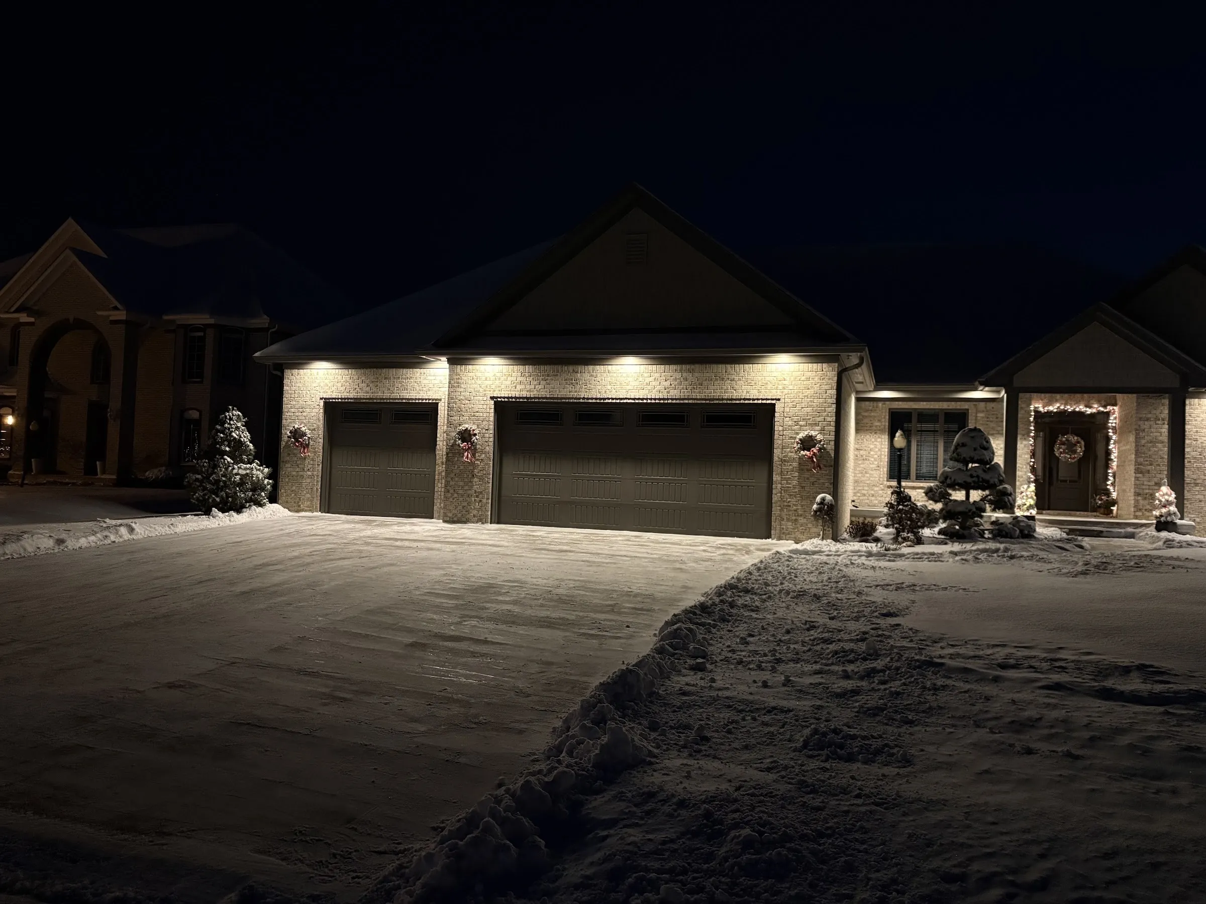A three-car drive cleared of snow at night.